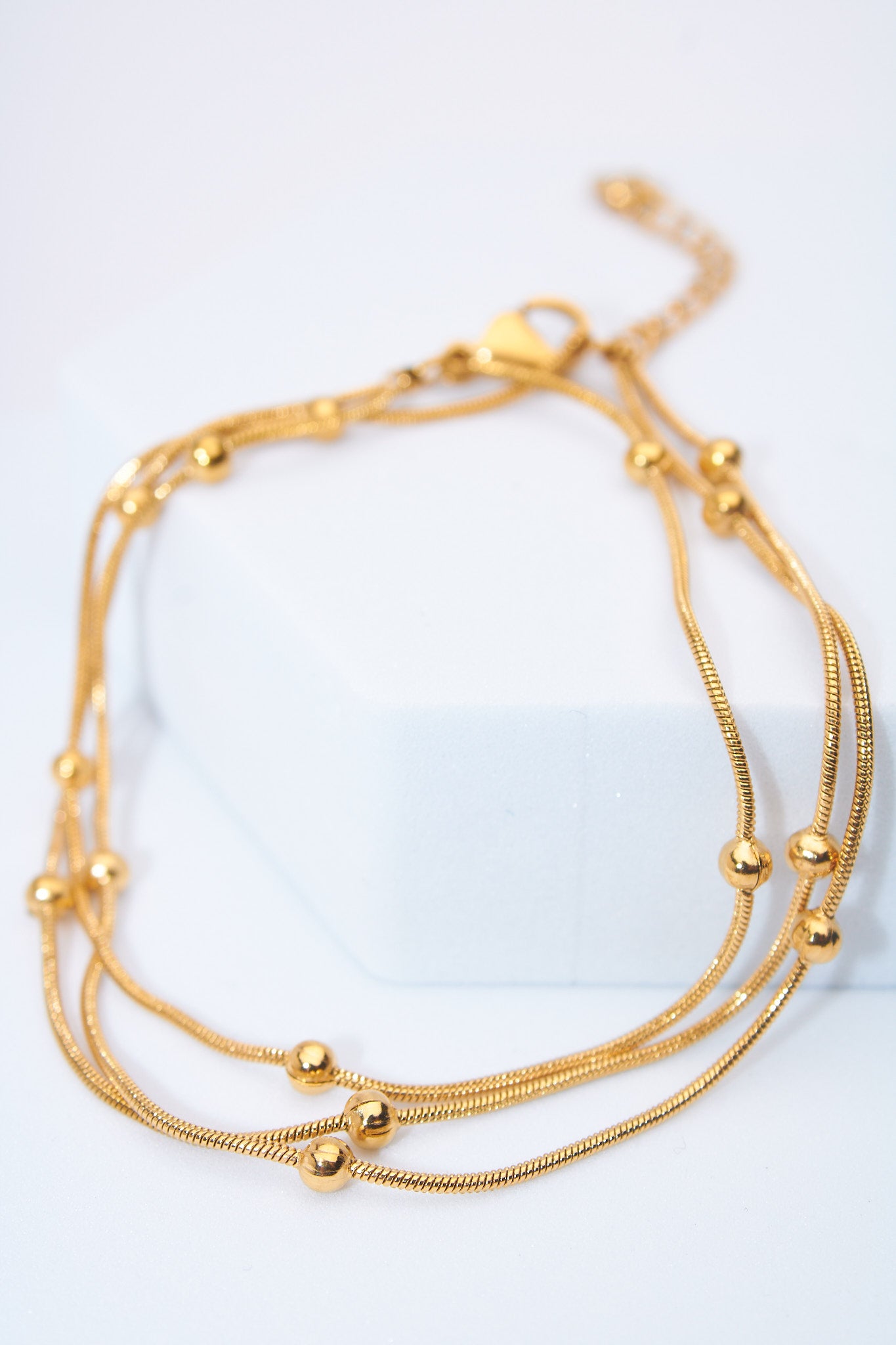 Pulsera malla triple con bolitas — baño dorado