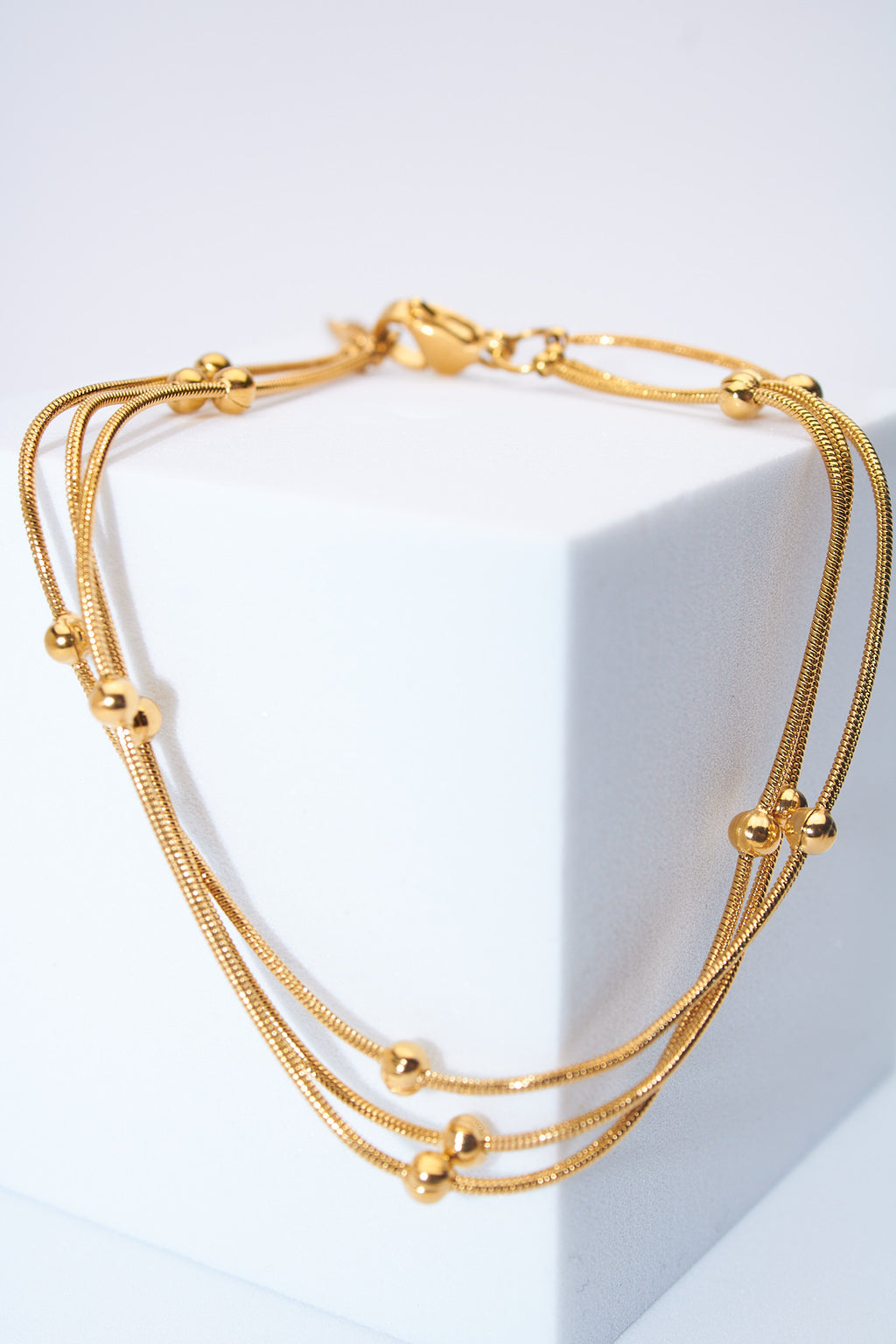 Pulsera malla triple con bolitas — baño dorado