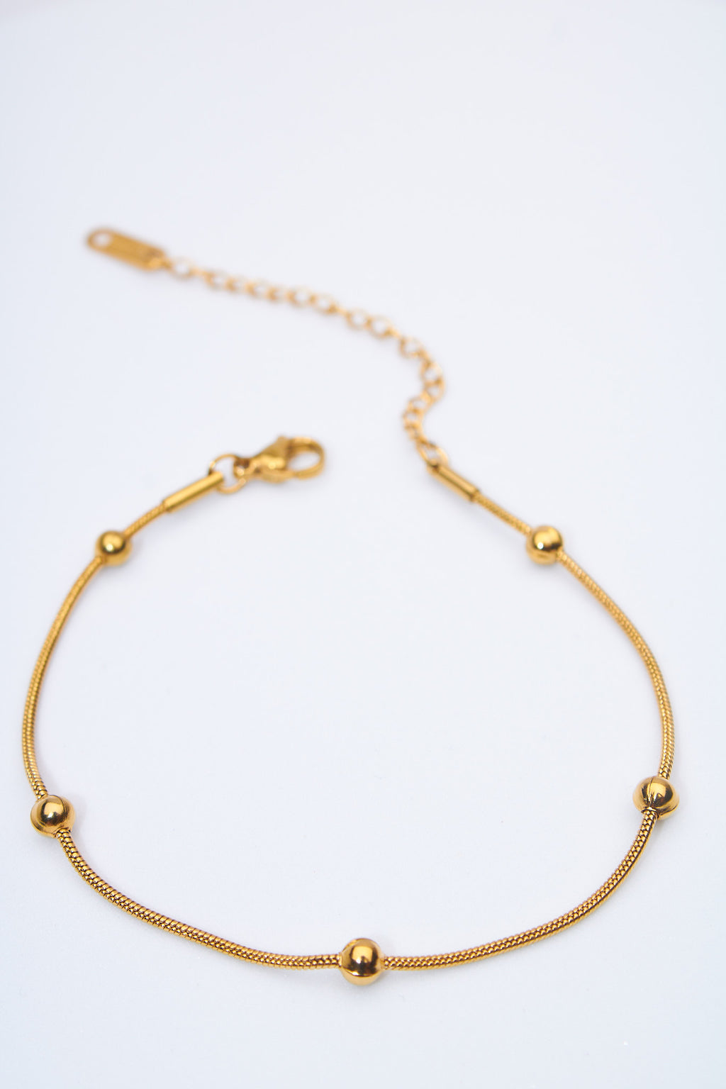 Pulsera fina con bolitas doradas — cadena serpiente