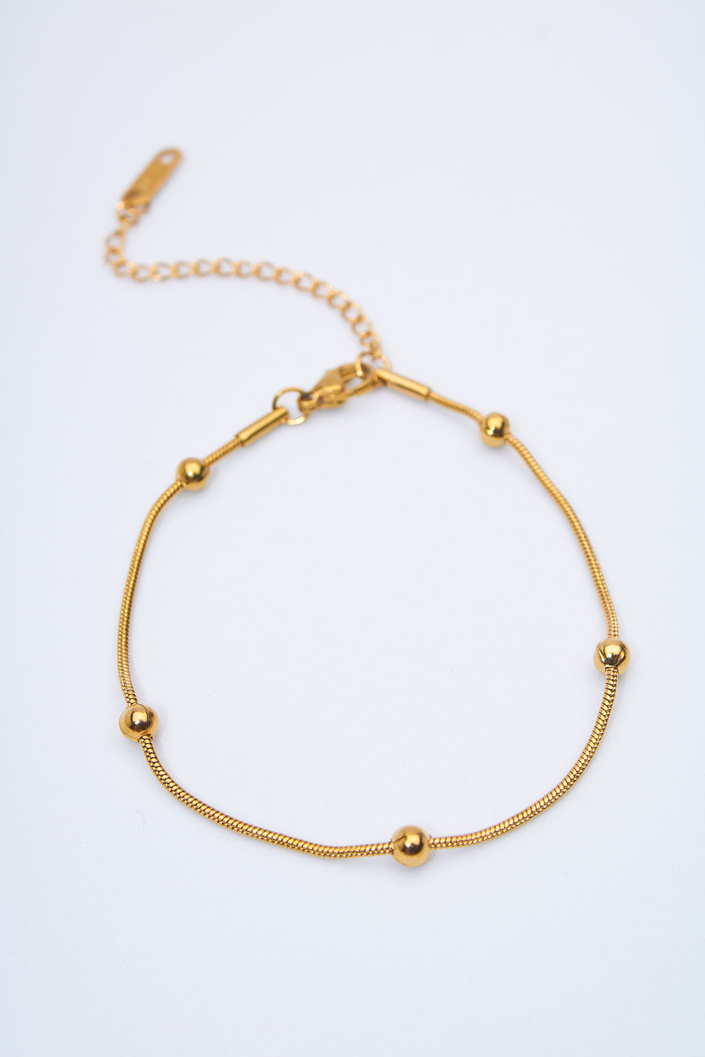 Pulsera fina con bolitas doradas — cadena serpiente