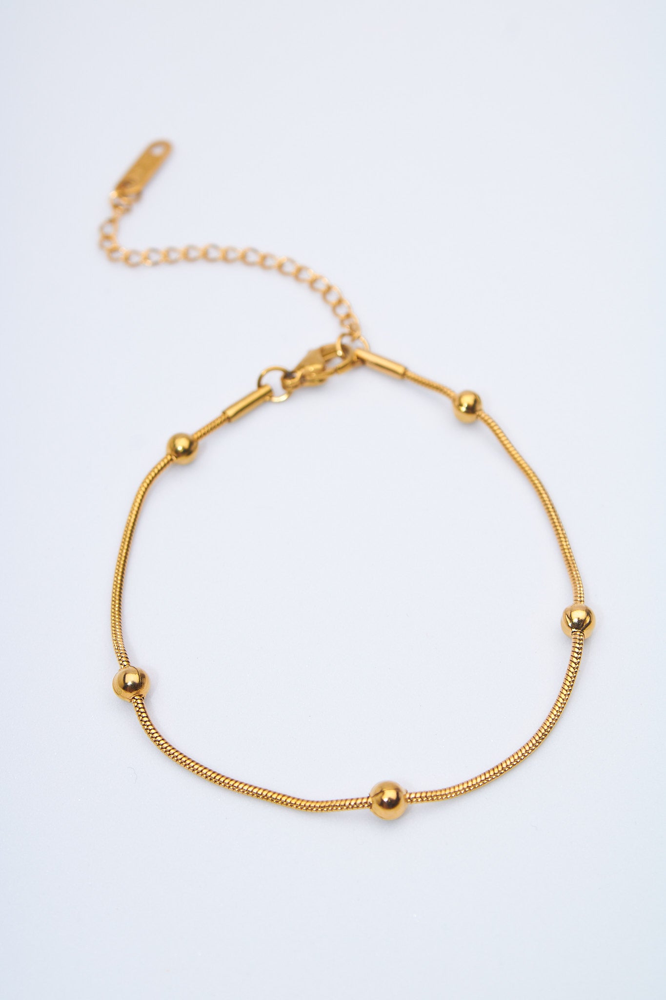 Pulsera fina con bolitas doradas — cadena serpiente