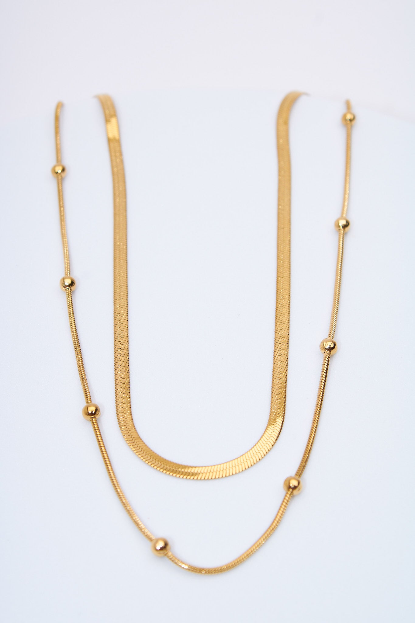 Collar doble capa — cadena plana + cadena con bolitas móviles, baño dorado