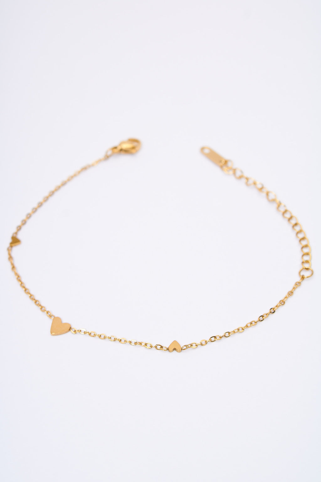 Pulsera fina con corazones espaciados — baño dorado