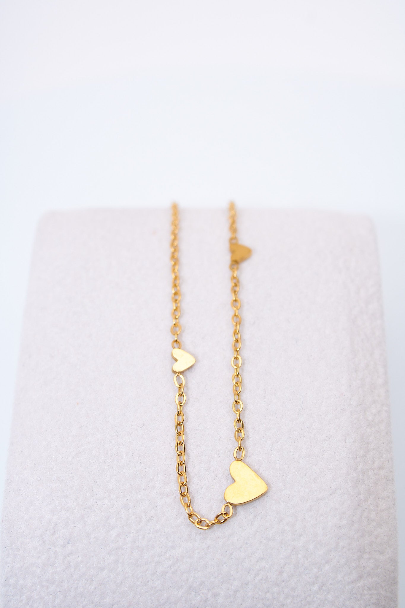 Pulsera fina con corazones espaciados — baño dorado