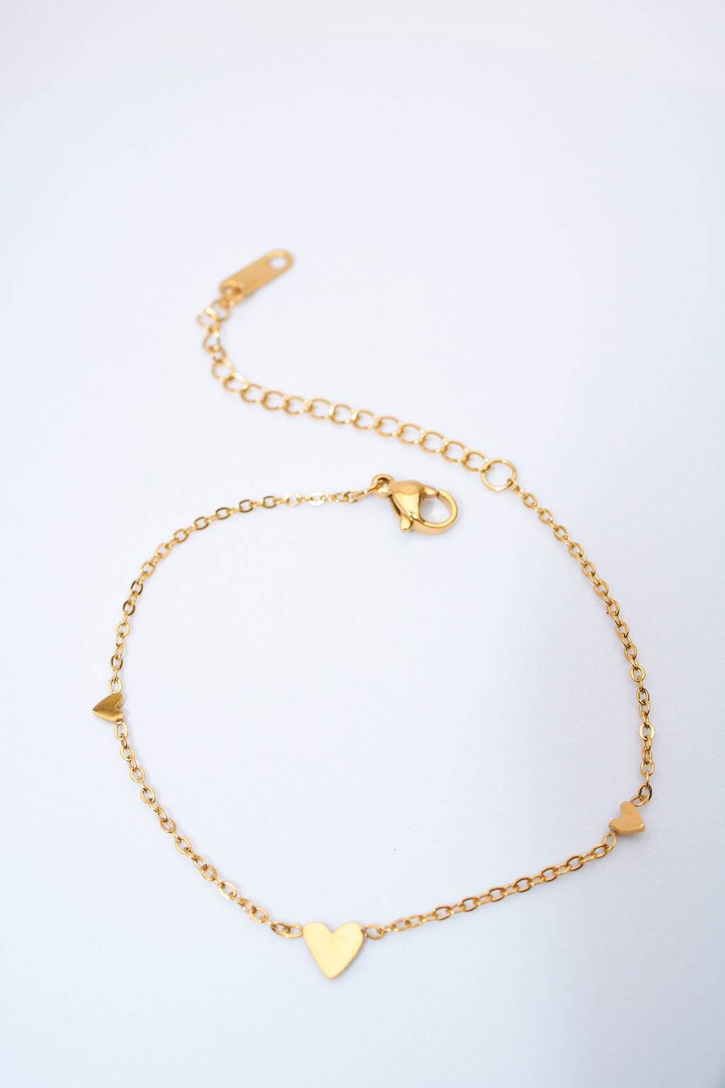 Pulsera fina con corazones espaciados — baño dorado