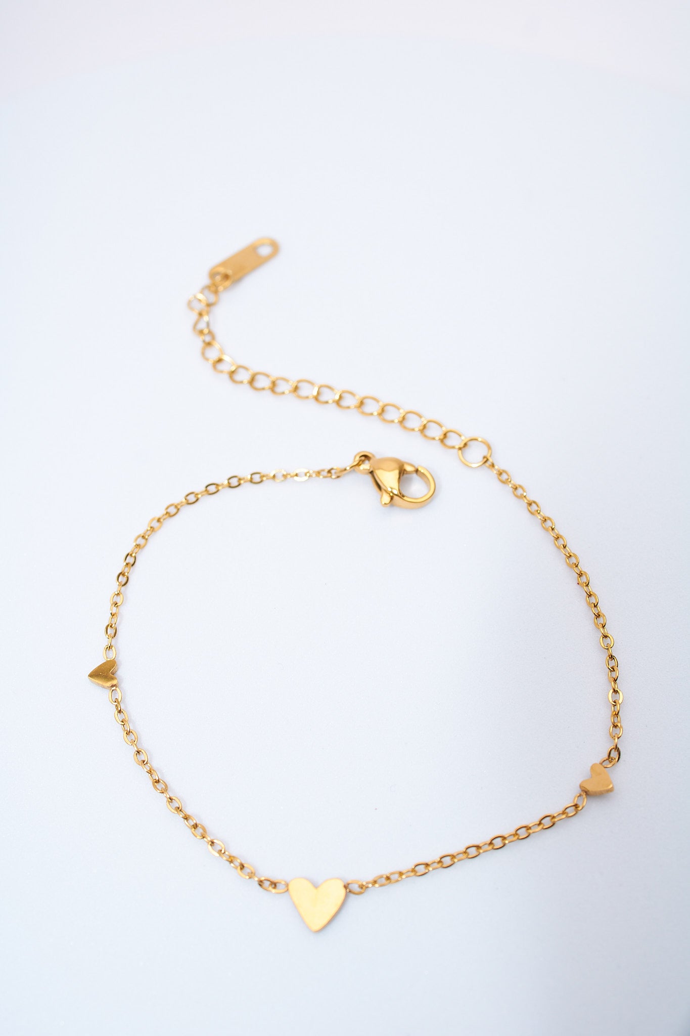 Pulsera fina con corazones espaciados — baño dorado