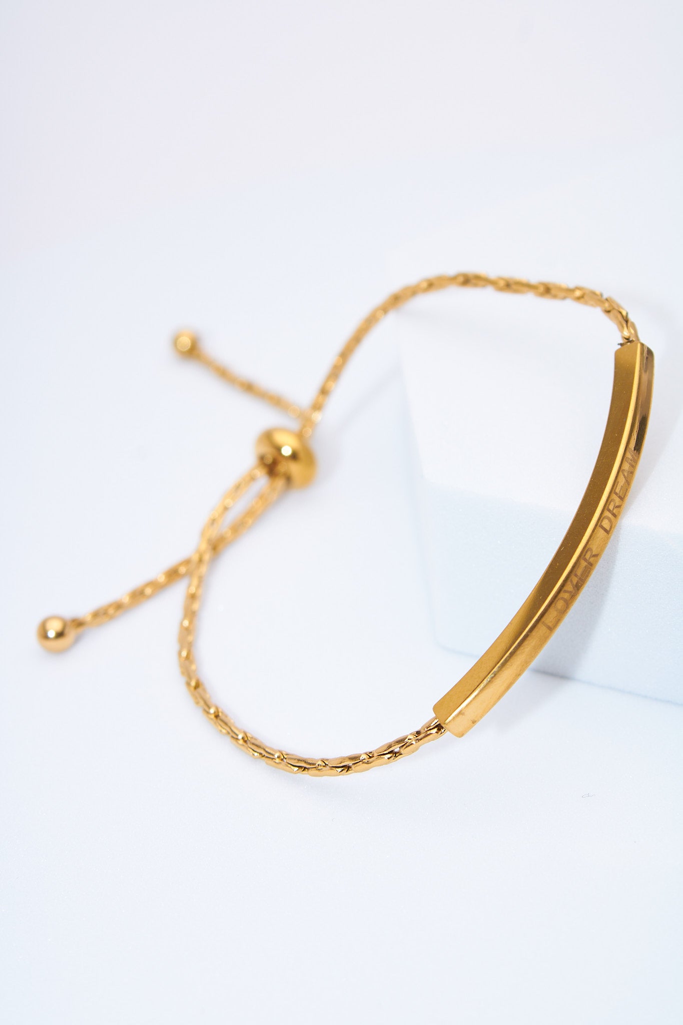 Pulsera ajustable barra curva dorada — cierre deslizante