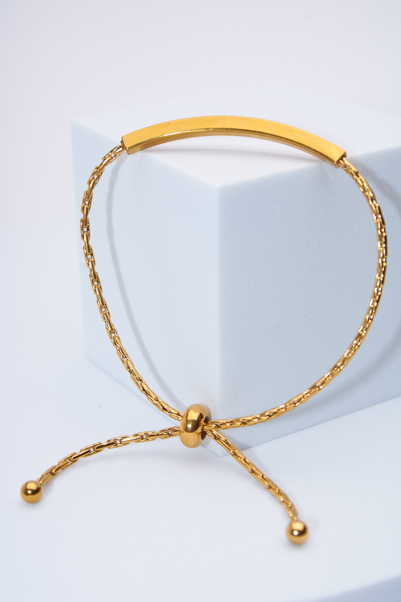 Pulsera ajustable barra curva dorada — cierre deslizante