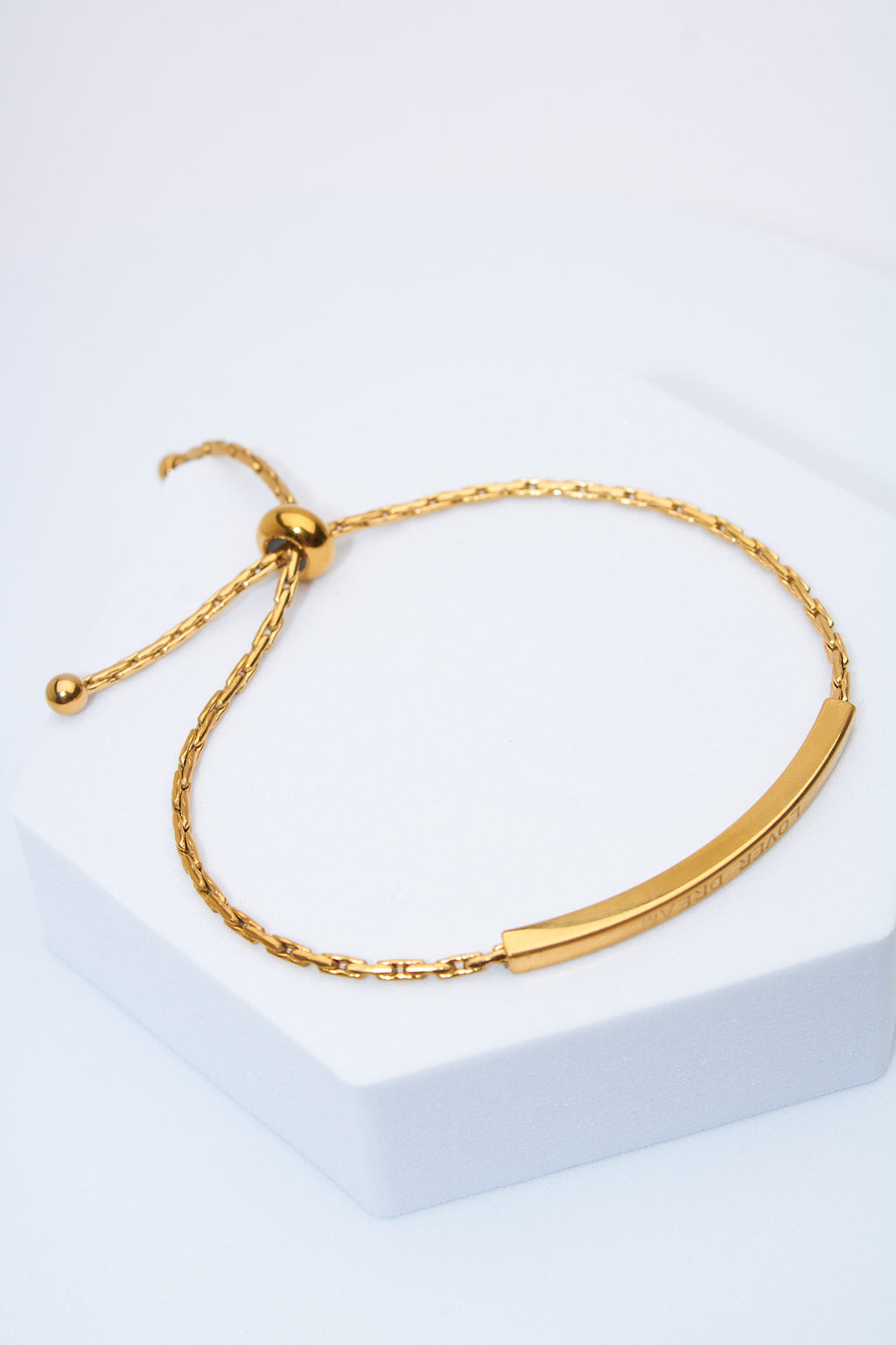 Pulsera ajustable barra curva dorada — cierre deslizante