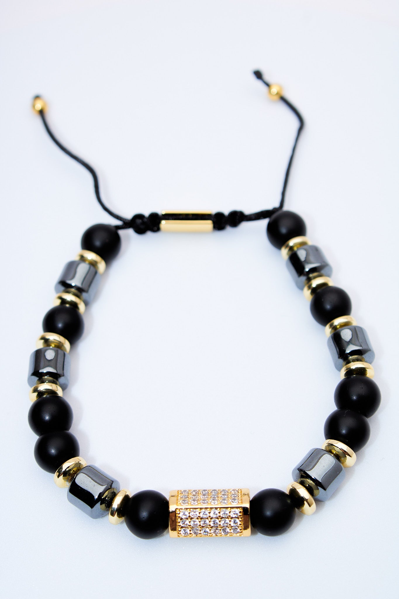 Pulsera ajustable de cuentas negras con detalle pavé dorado