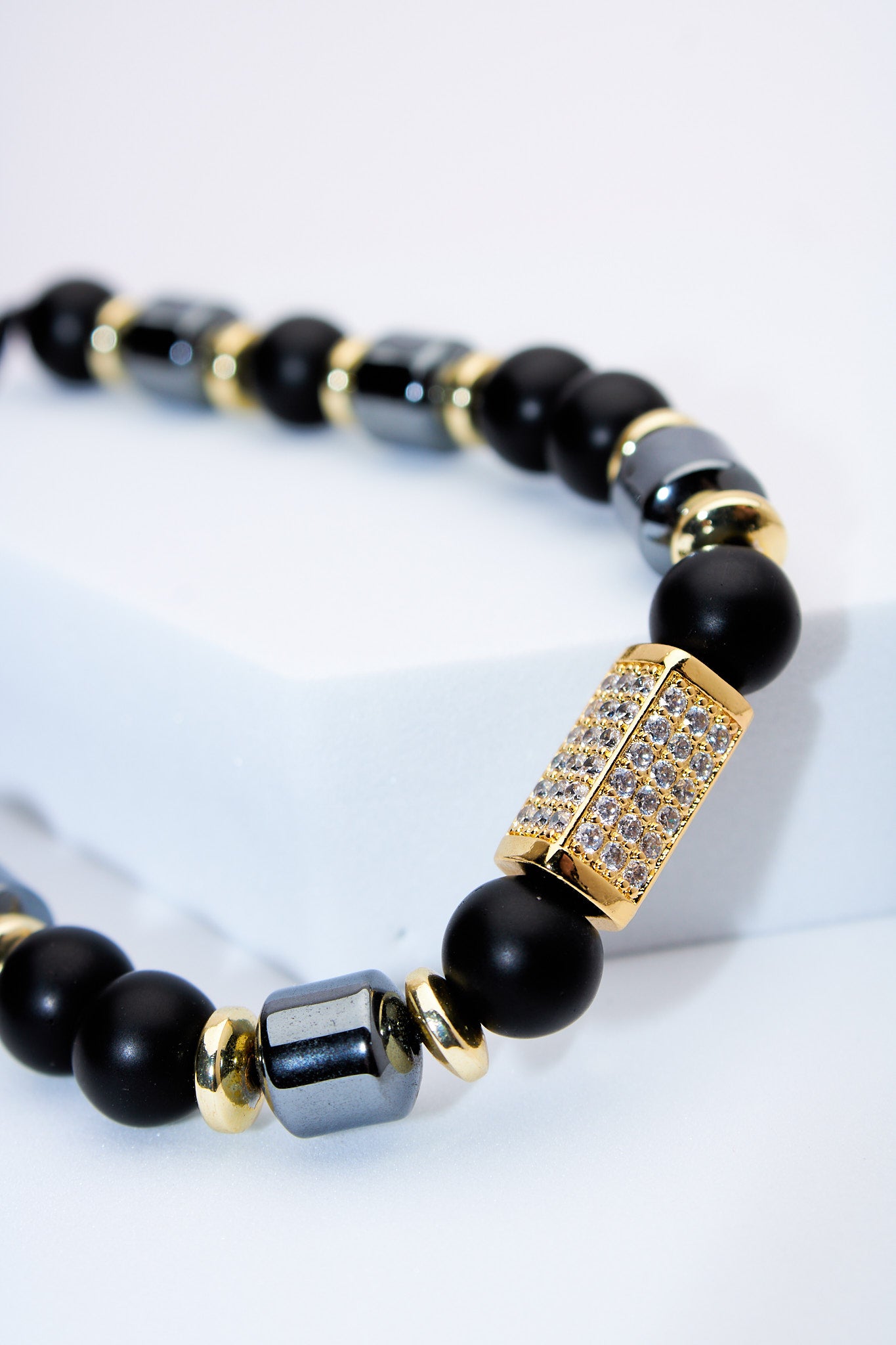 Pulsera ajustable de cuentas negras con detalle pavé dorado