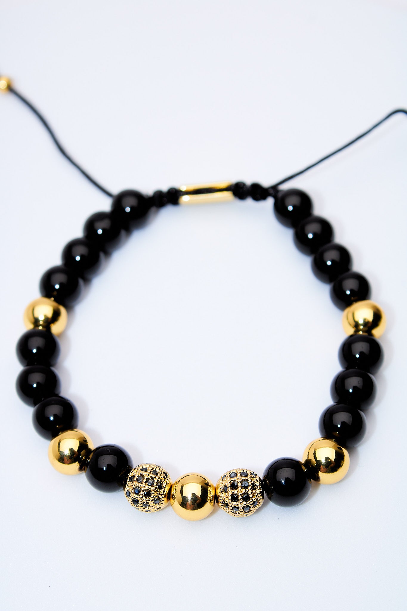 Pulsera ajustable ónix y bolitas doradas con pavé negro