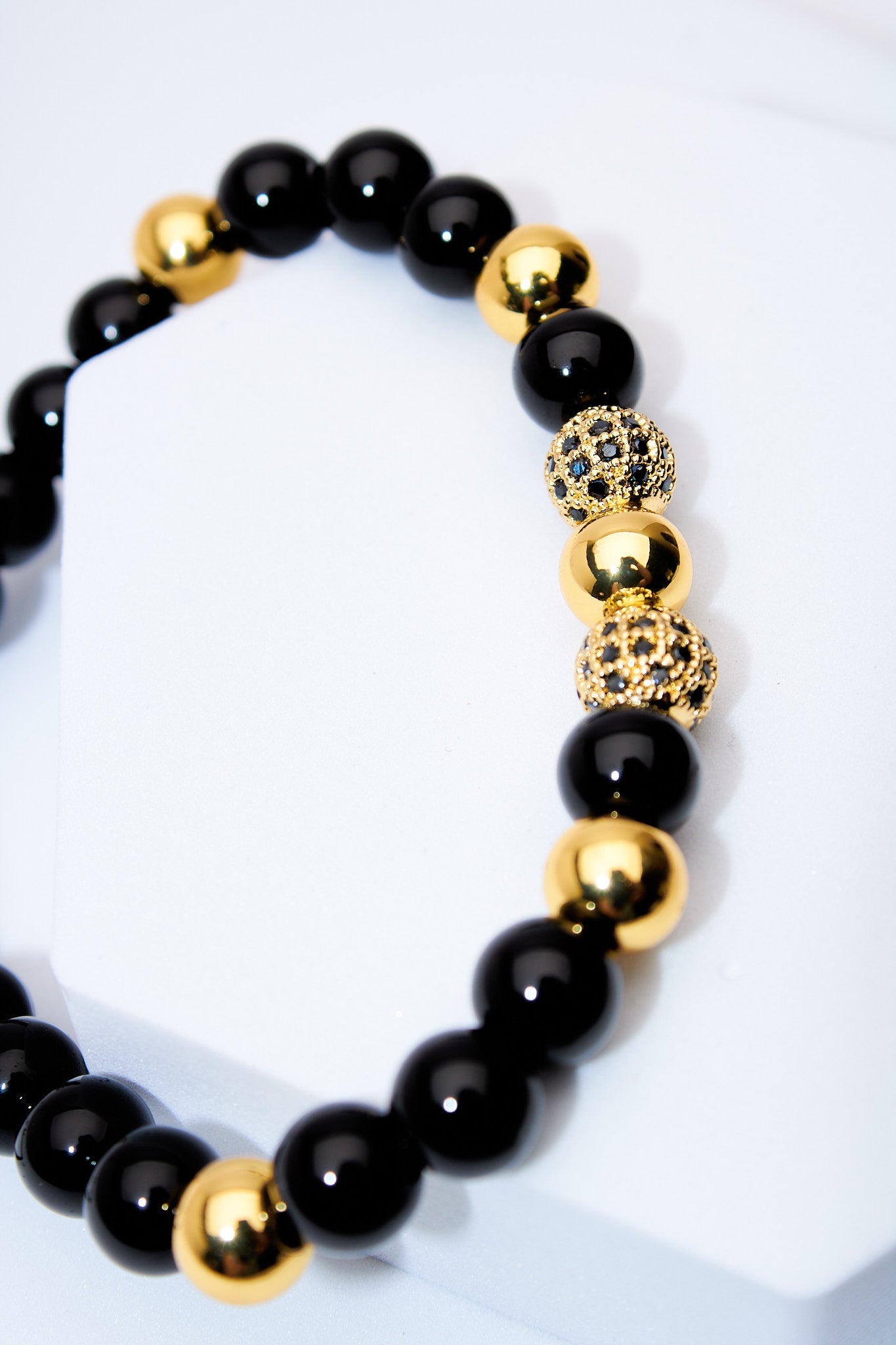 Pulsera ajustable ónix y bolitas doradas con pavé negro