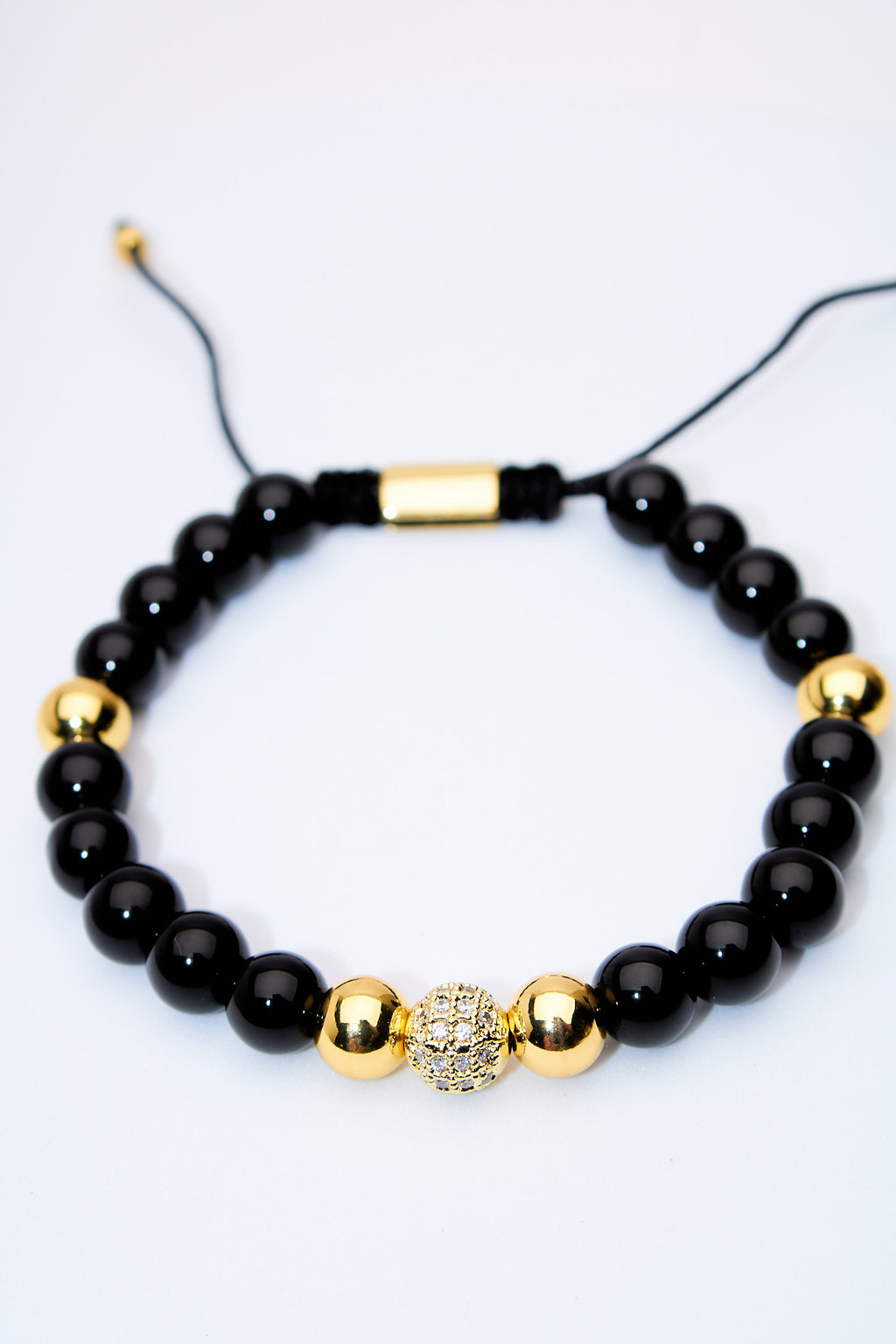Pulsera ajustable ónix con bolitas doradas y centro pavé
