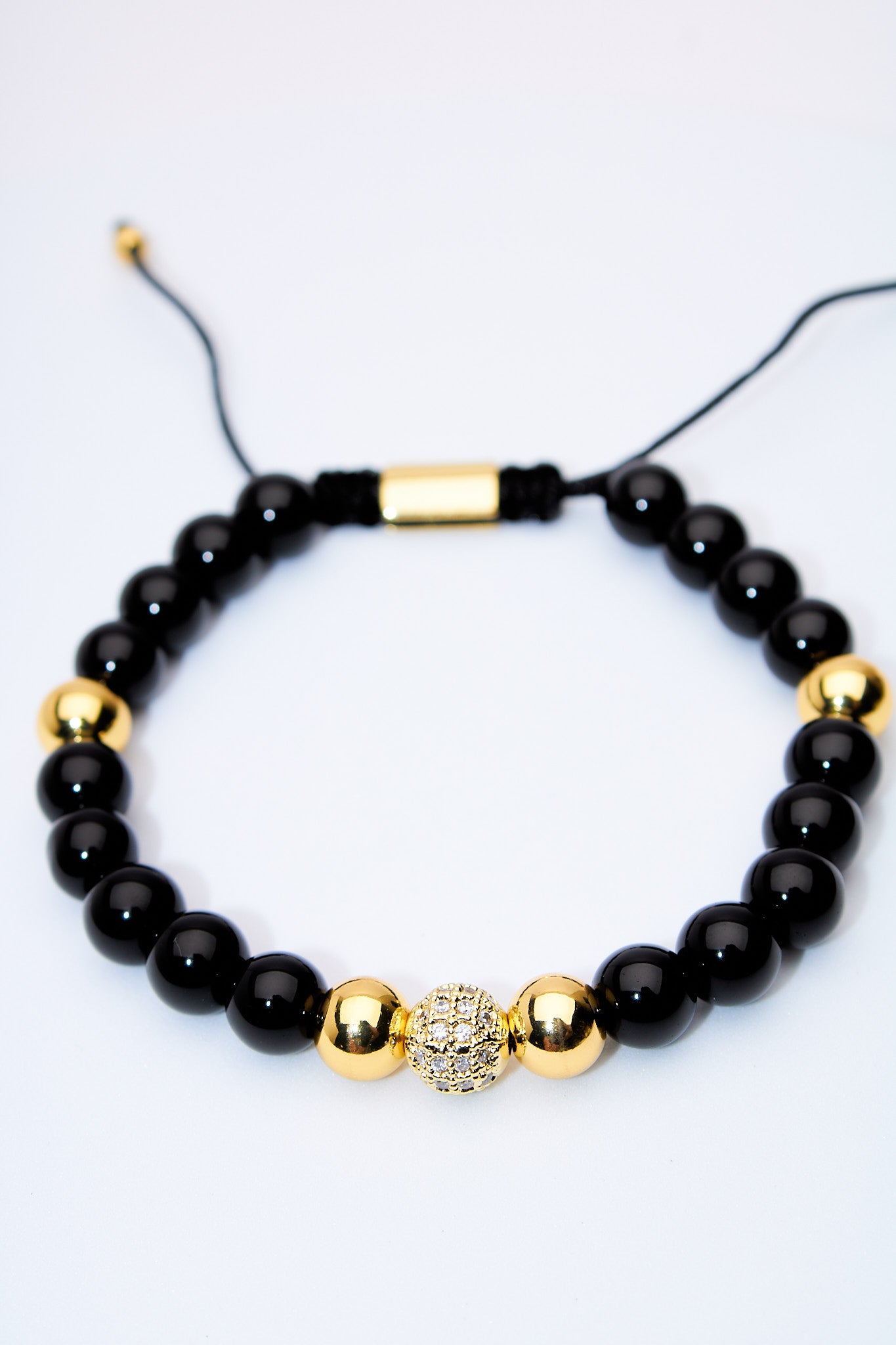 Pulsera ajustable ónix con bolitas doradas y centro pavé