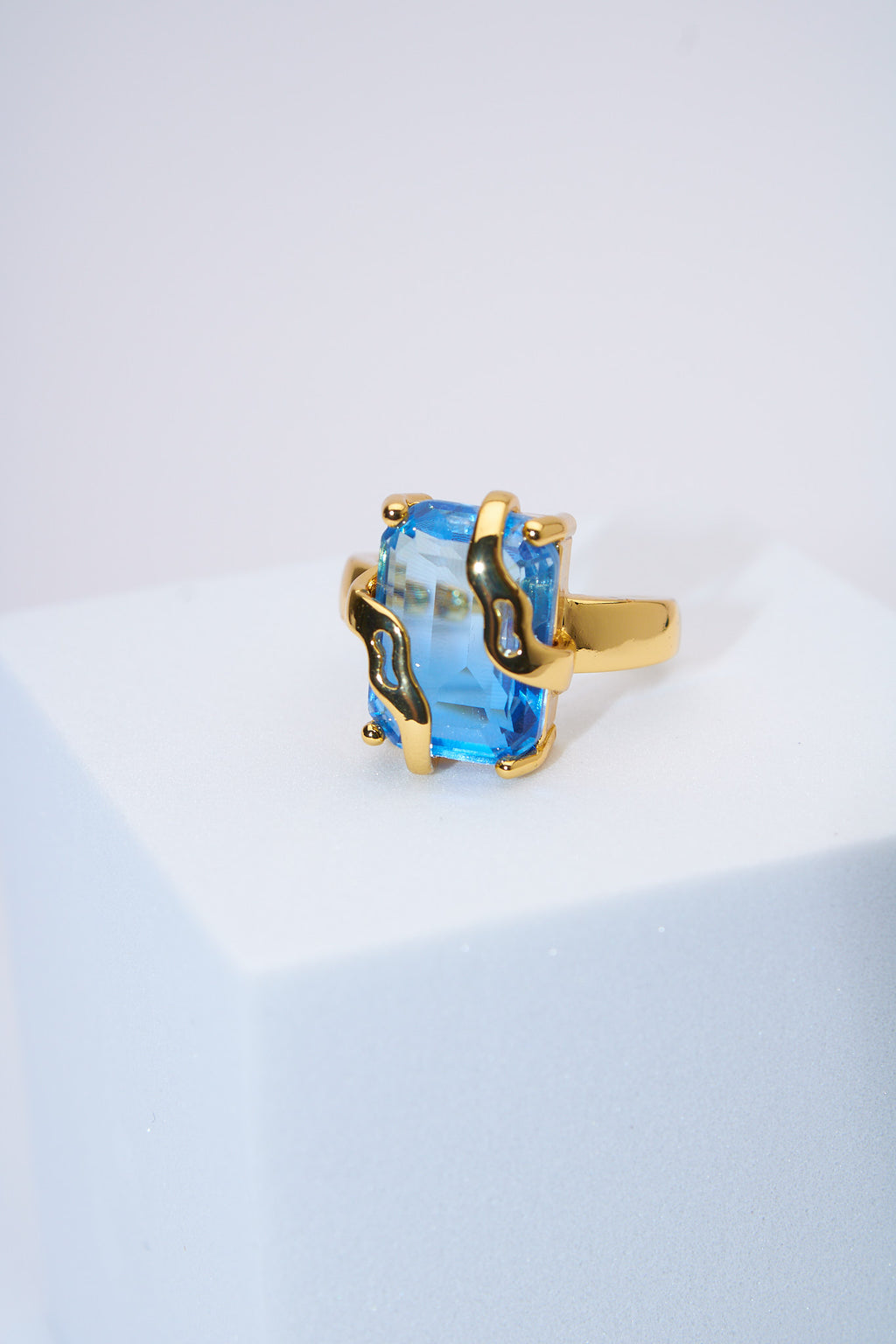 Anillo con piedra azul facetada — baño dorado