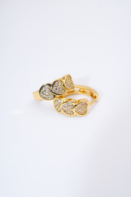 Aretes huggie corazones pavé dorados