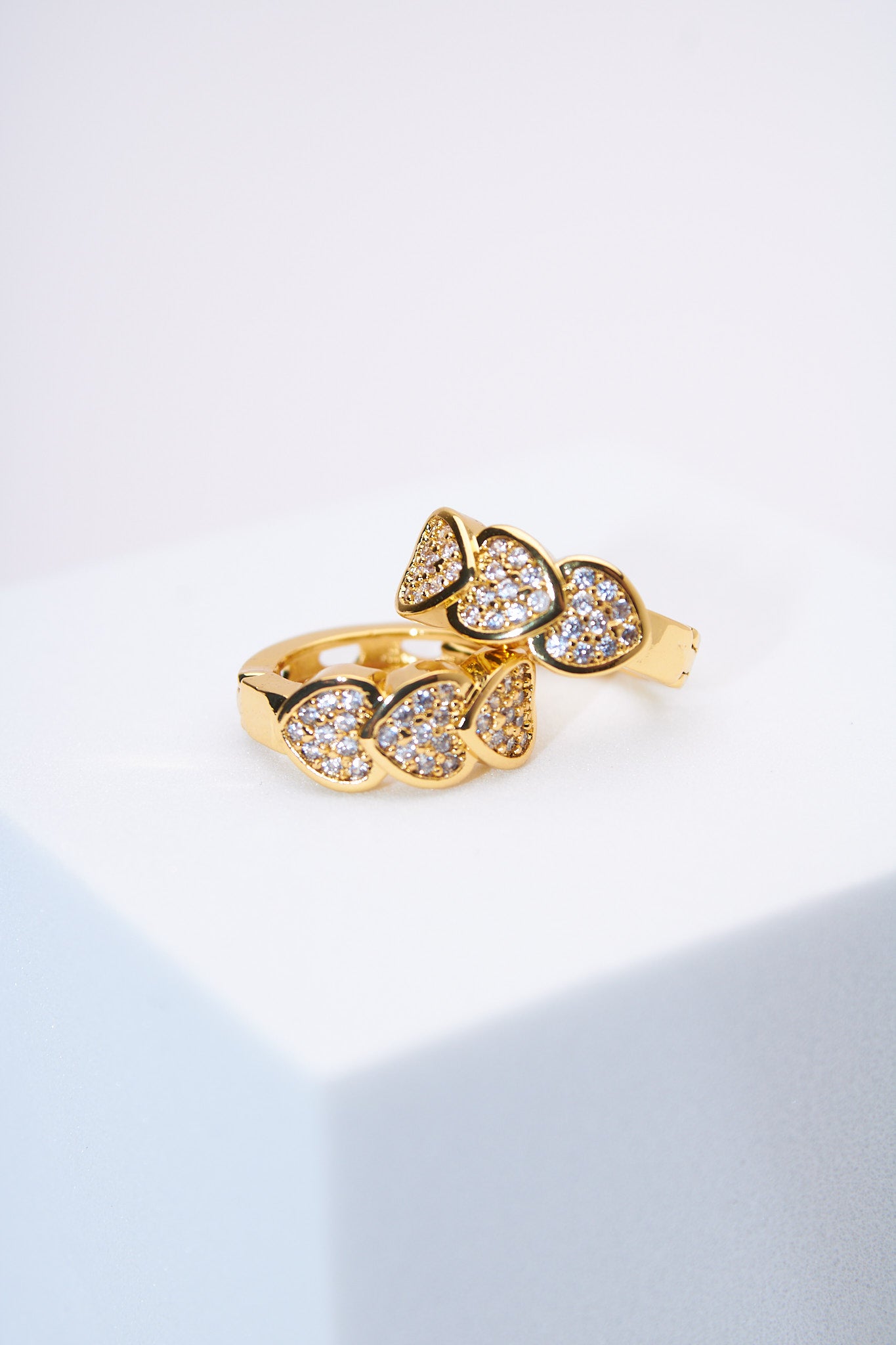 Aretes huggie corazones pavé dorados