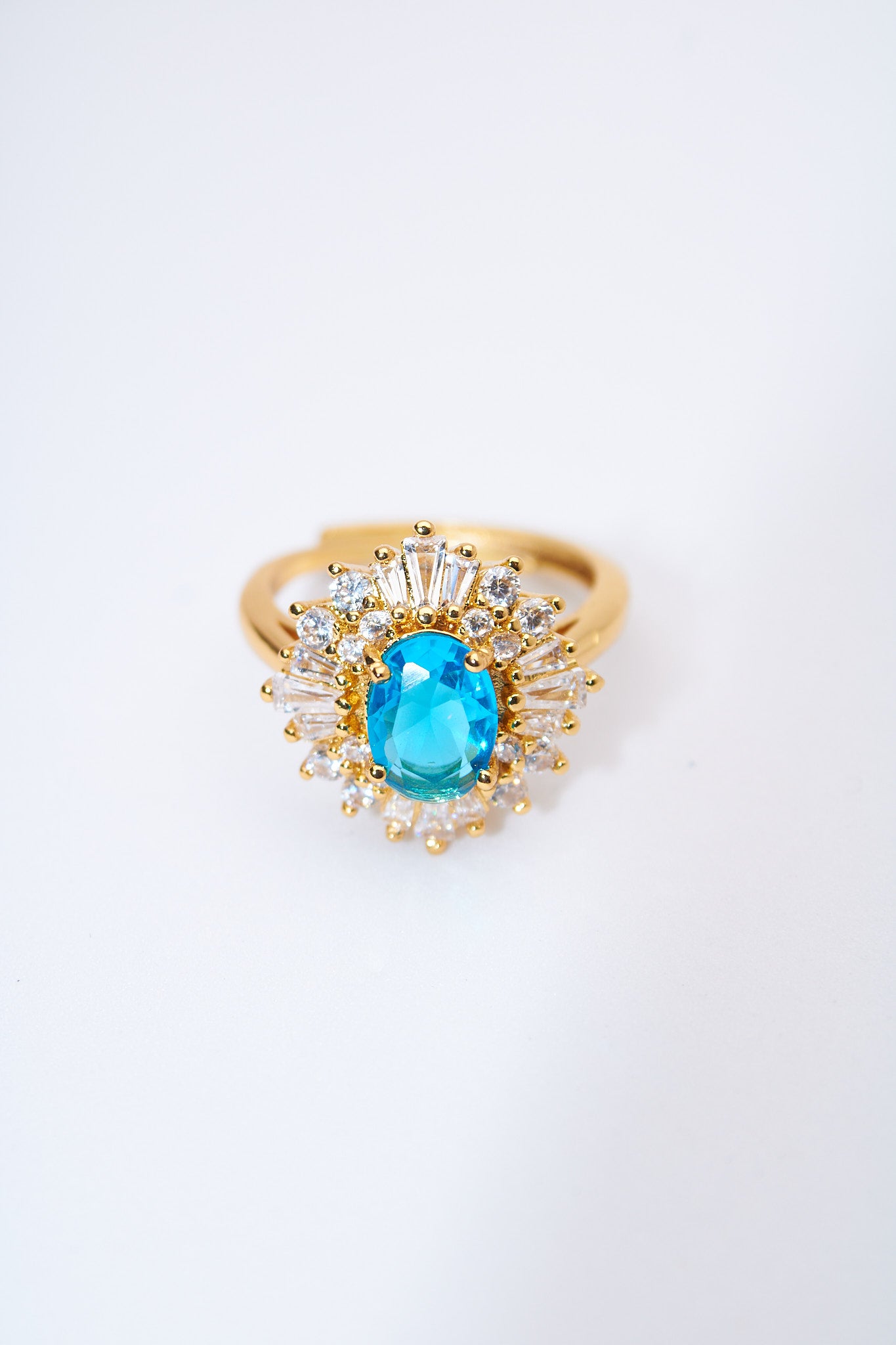 Anillo solitario floral con piedra azul y halo de cristales — baño dorado