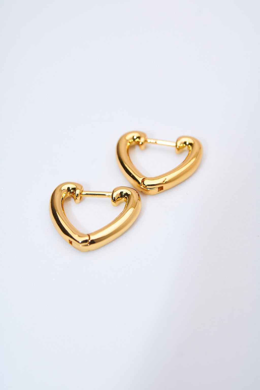 Aretes corazón hueco dorados — acabado pulido