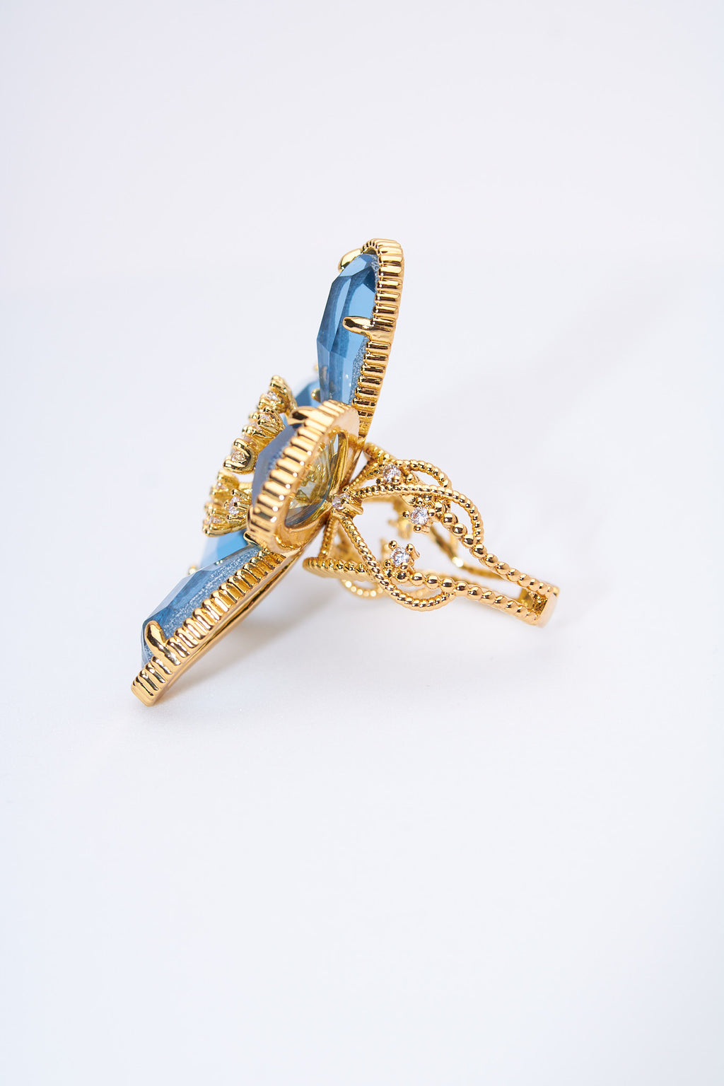 Anillo flor con pétalos lágrima azul claro — baño dorado