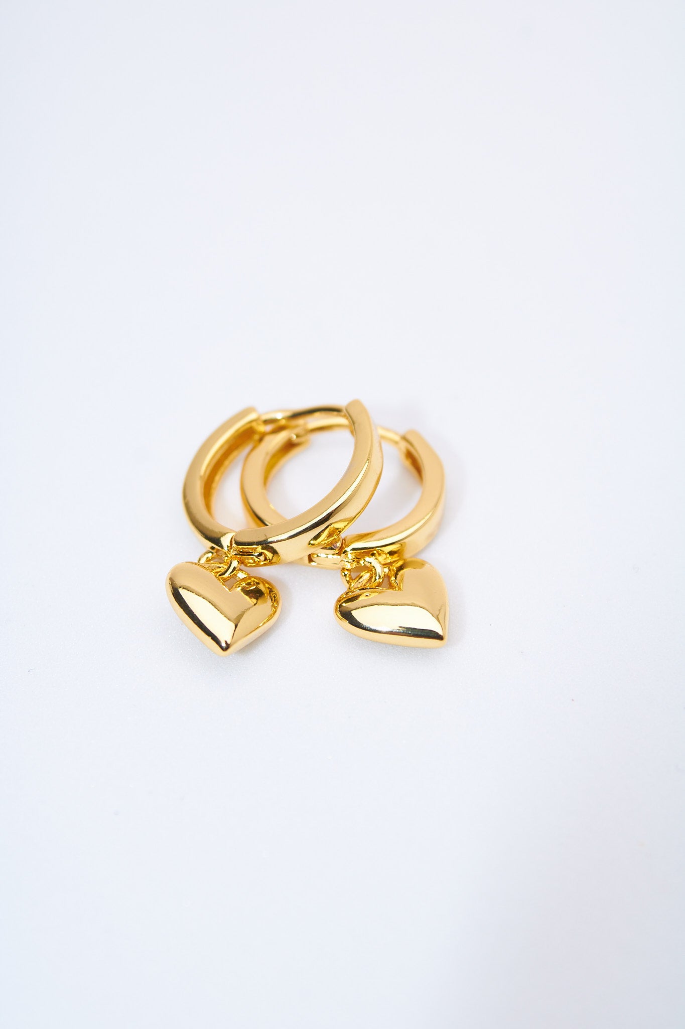 Aretes huggie con corazón macizo dorado