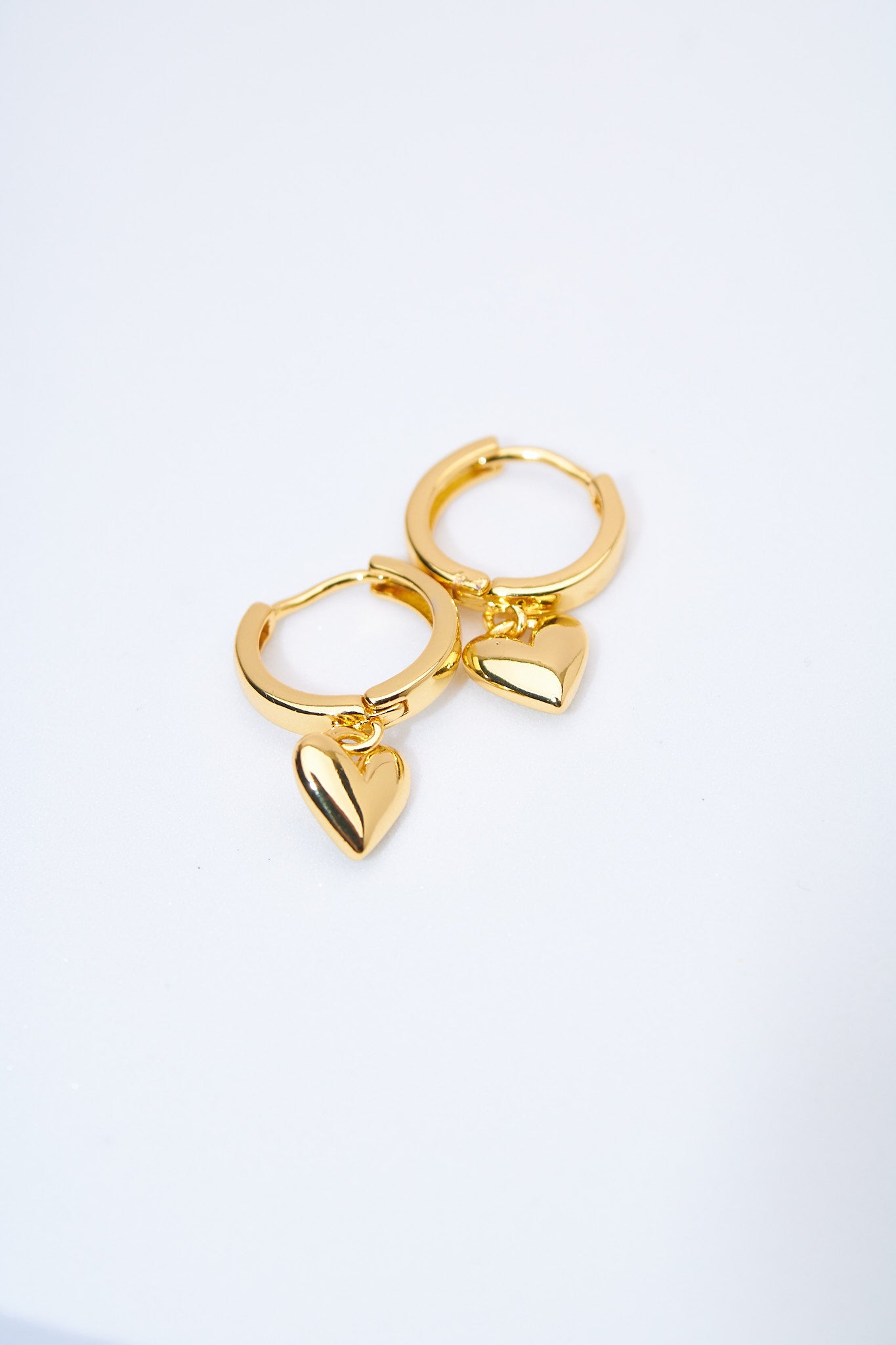 Aretes huggie con corazón macizo dorado