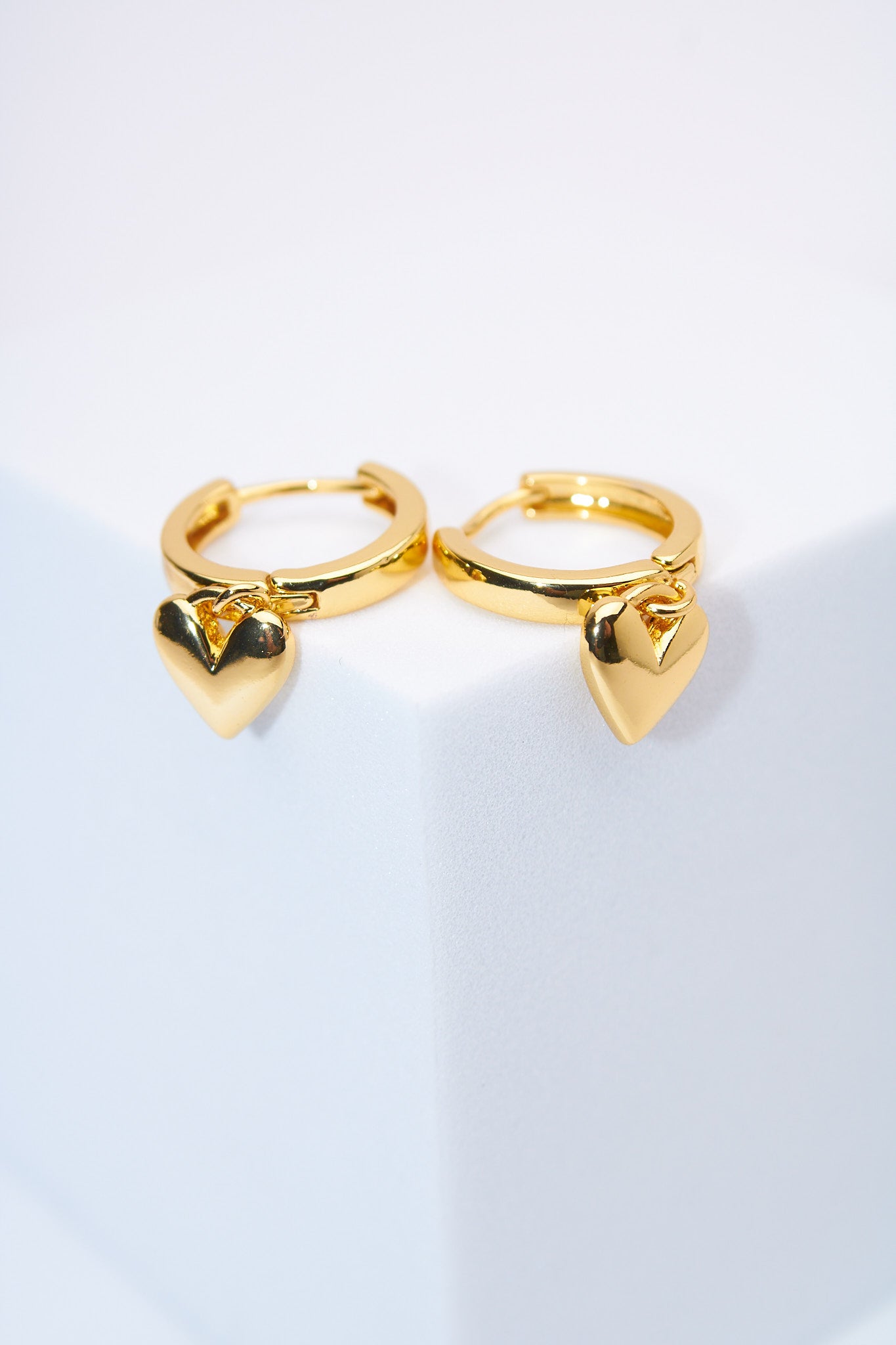 Aretes huggie con corazón macizo dorado