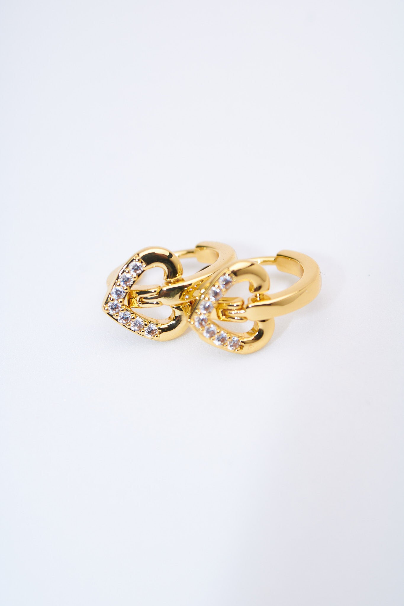 Aretes huggie con corazones pavé dorados