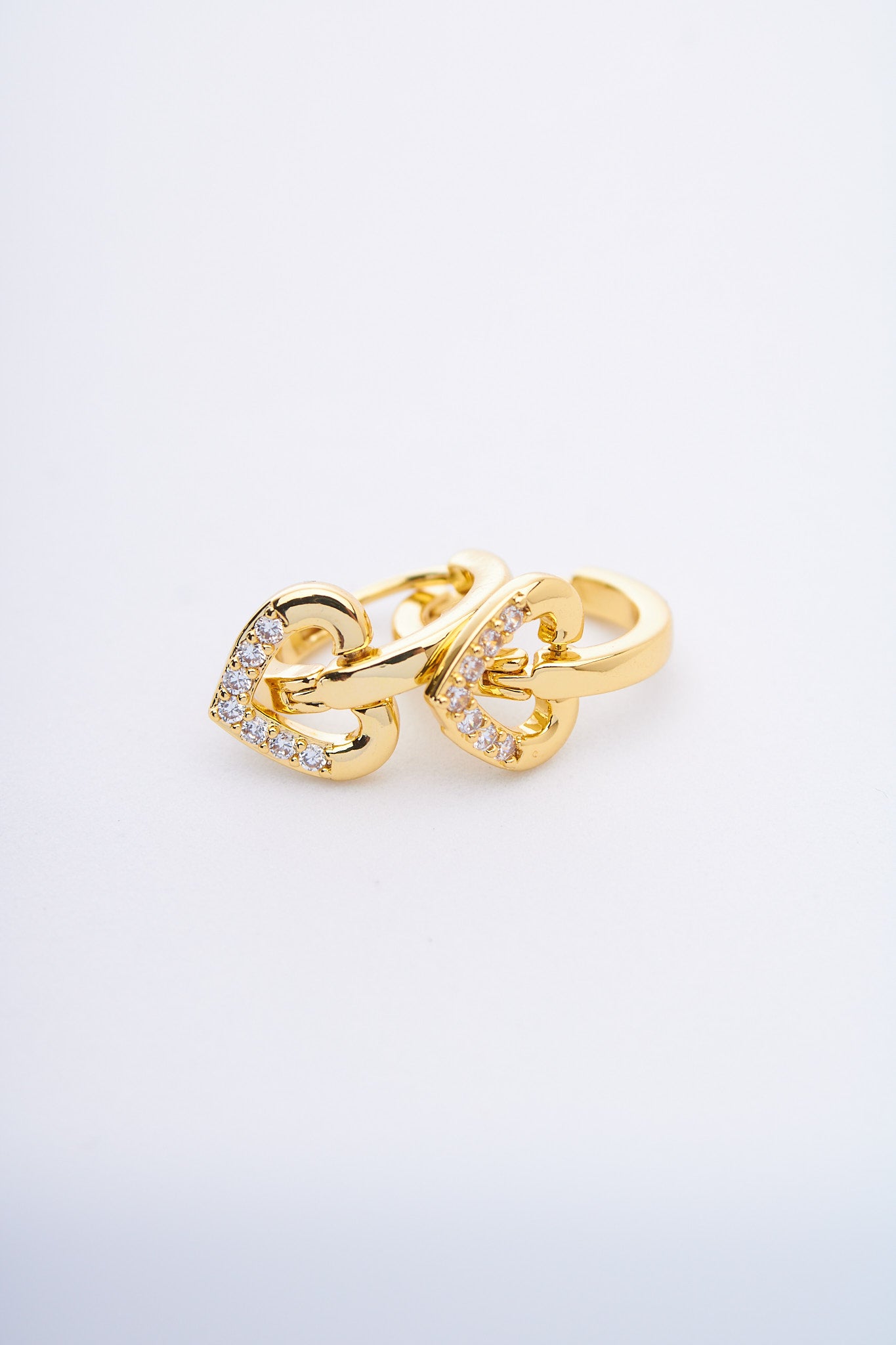 Aretes huggie con corazones pavé dorados