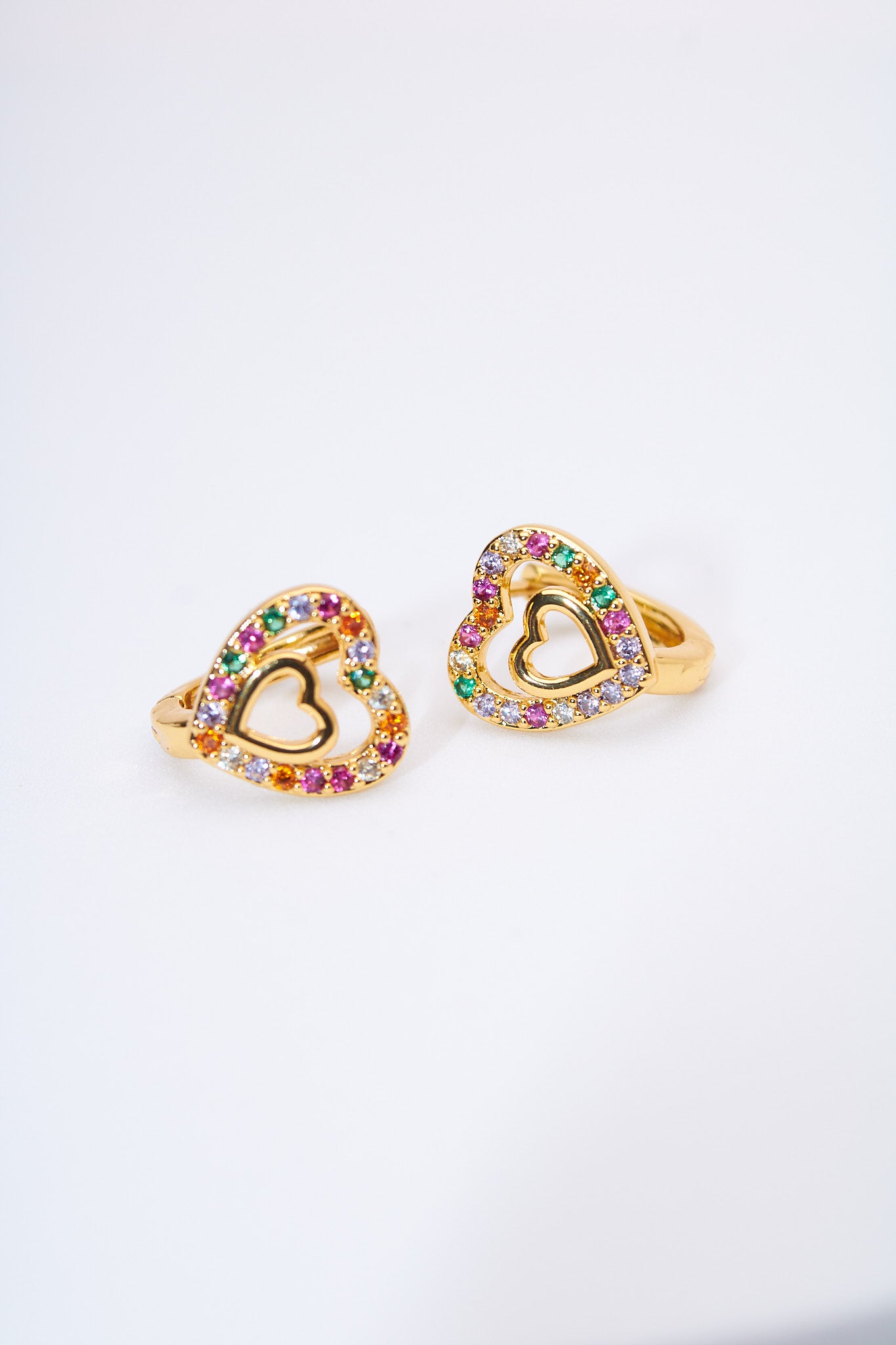 Aretes huggie corazones multicolor pavé — baño dorado