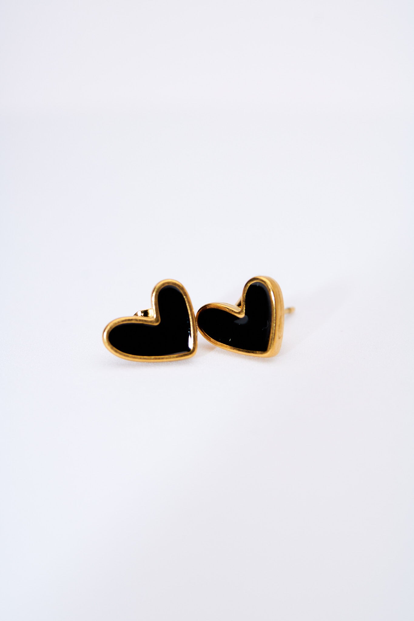 Aretes corazón esmaltado negro — marco dorado