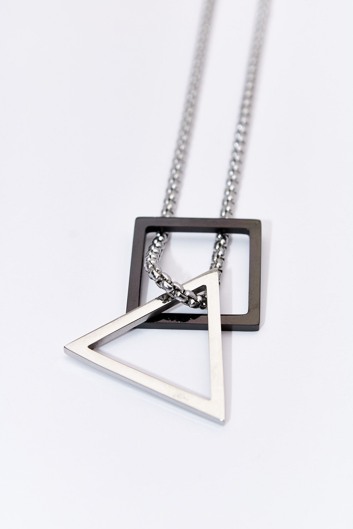 Collar doble geométrico — rombo negro + triángulo plateado