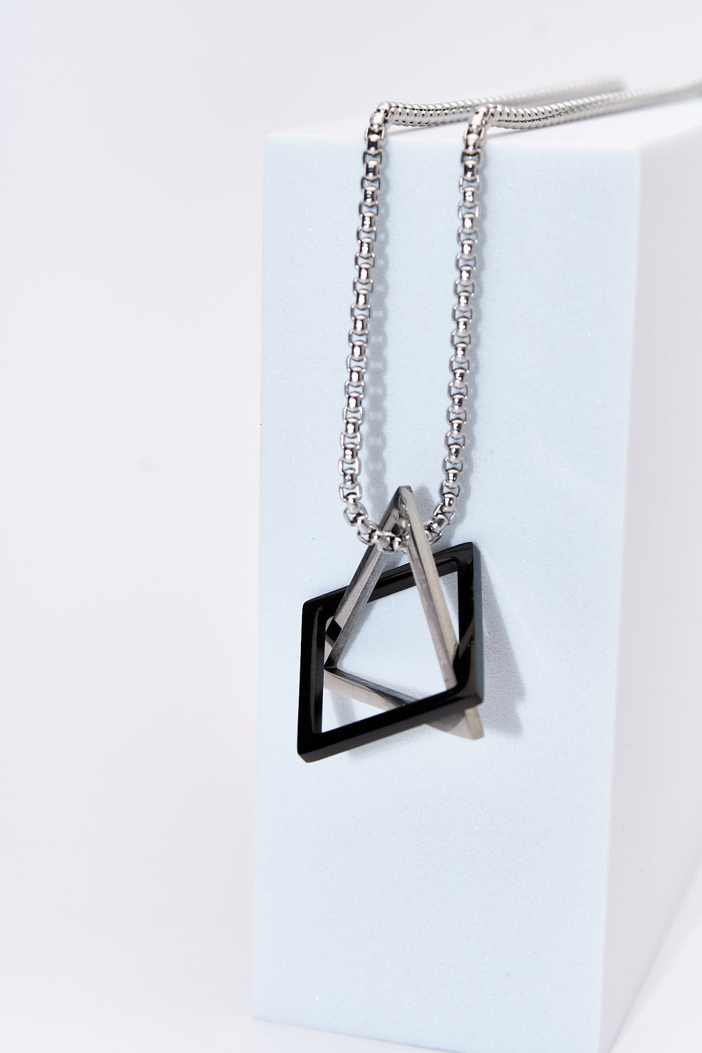 Collar doble geométrico — rombo negro + triángulo plateado