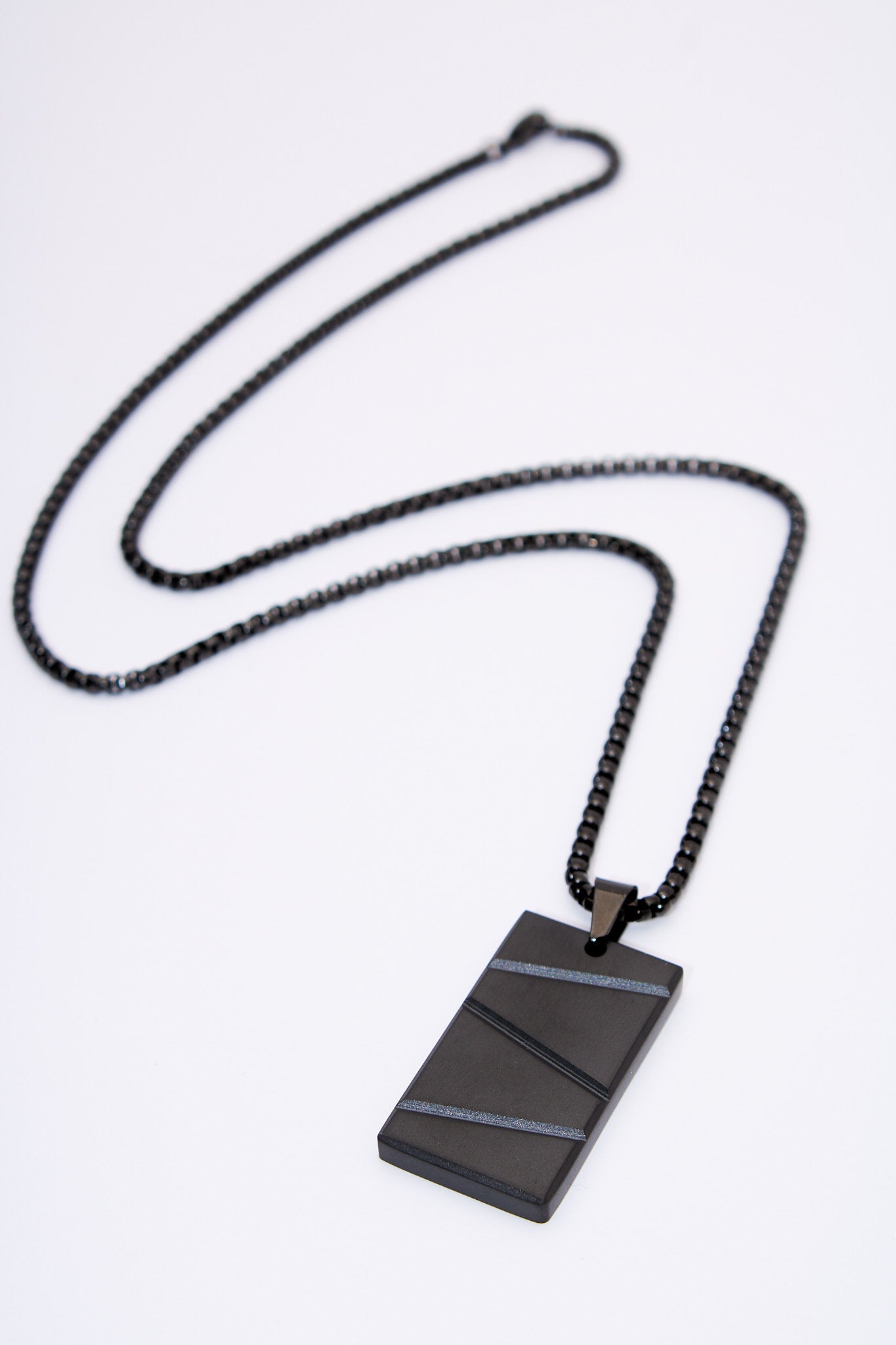 Collar placa rectangular negra con franjas texturadas