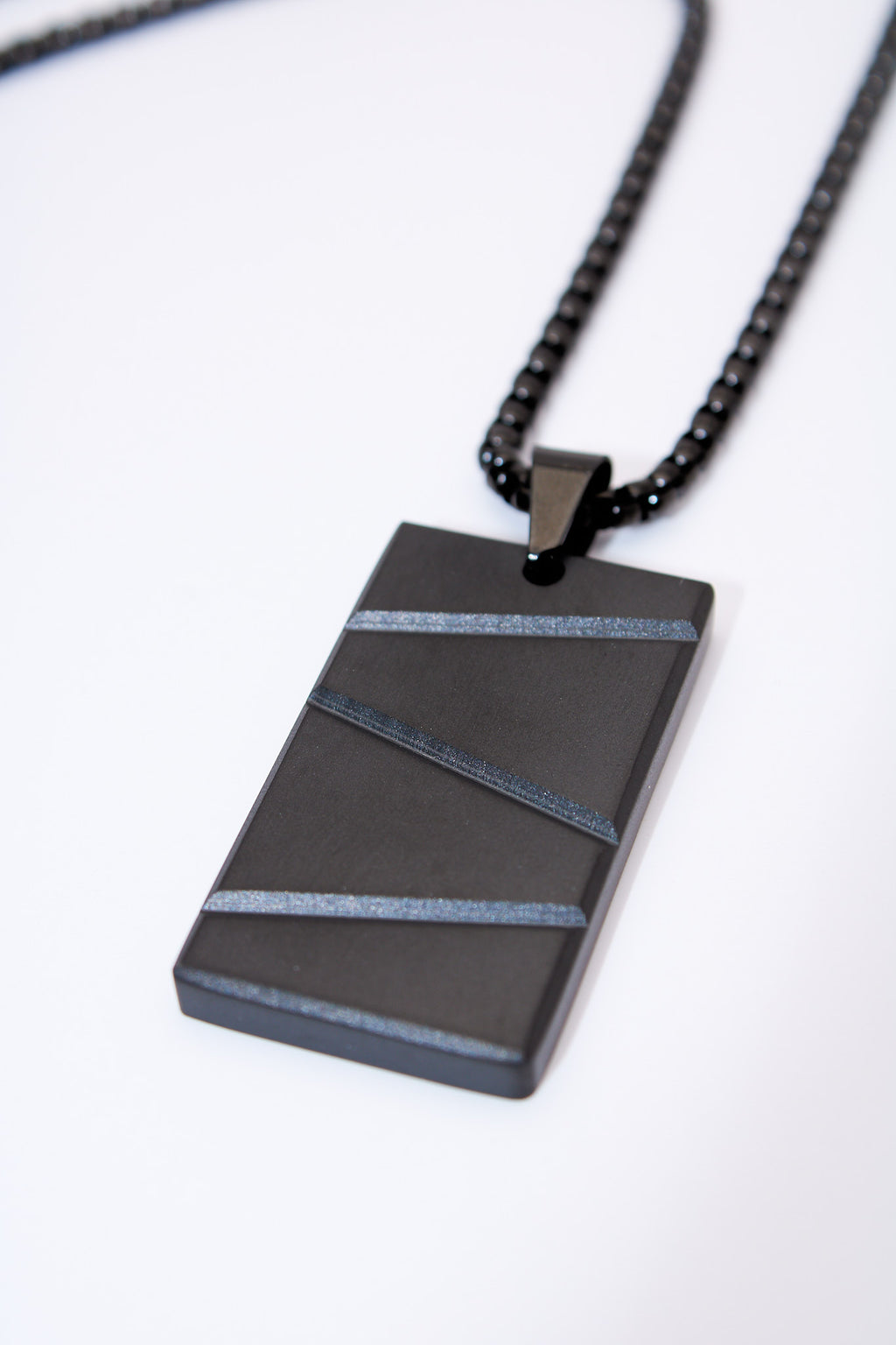 Collar placa rectangular negra con franjas texturadas