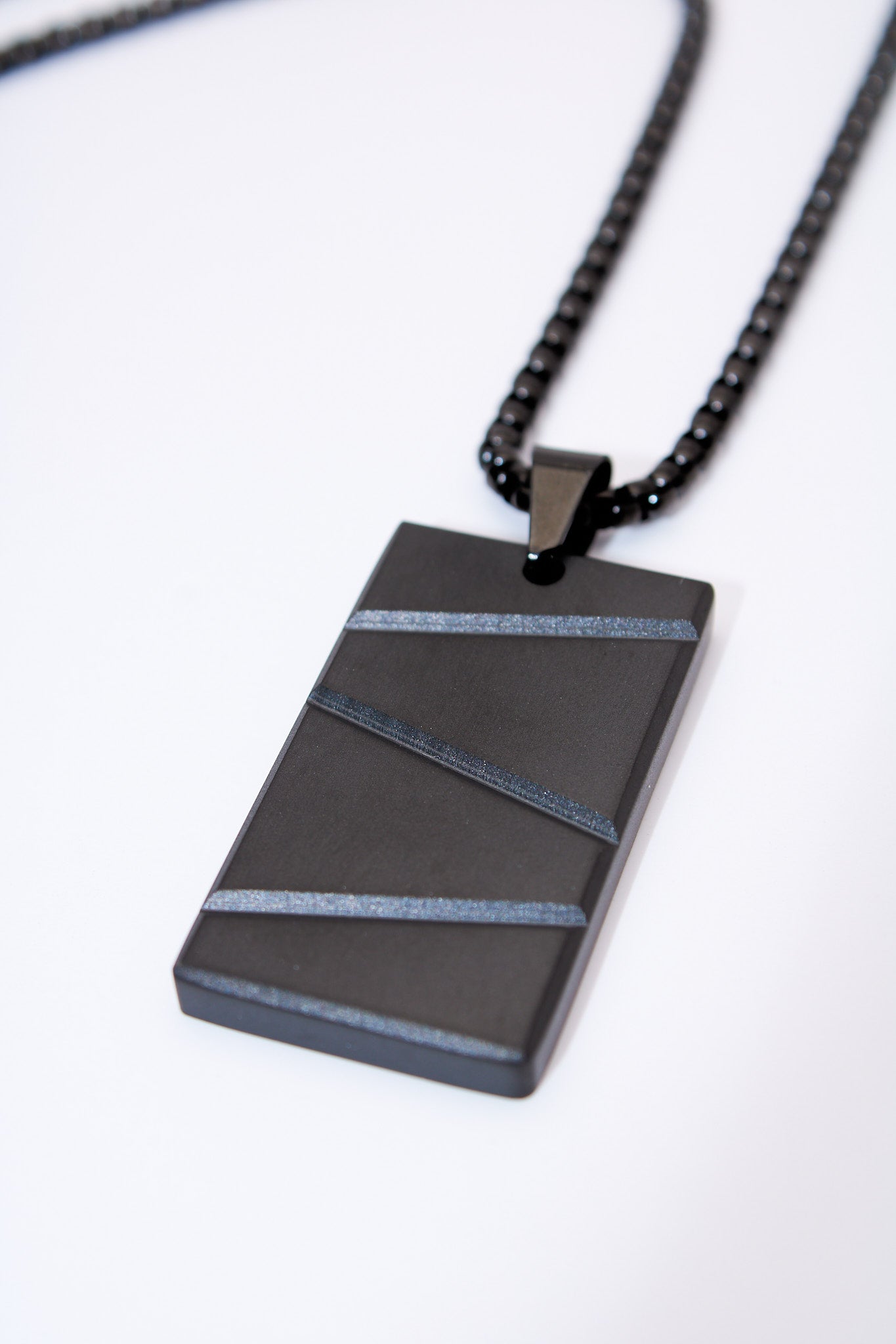 Collar placa rectangular negra con franjas texturadas