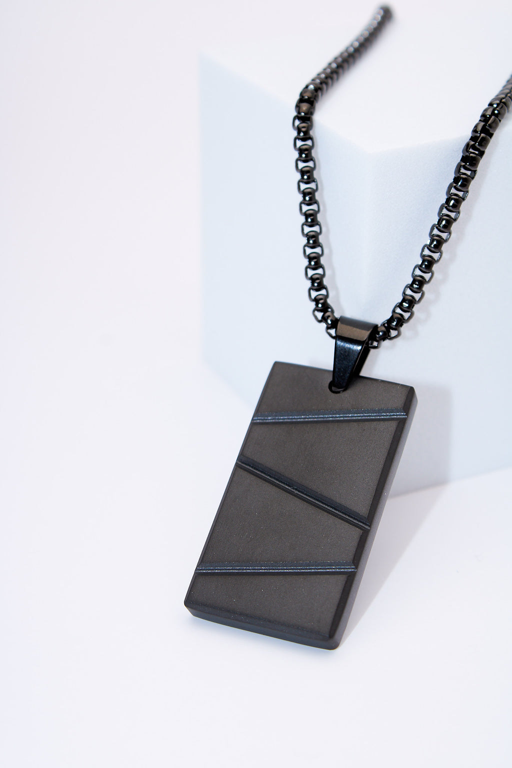 Collar placa rectangular negra con franjas texturadas