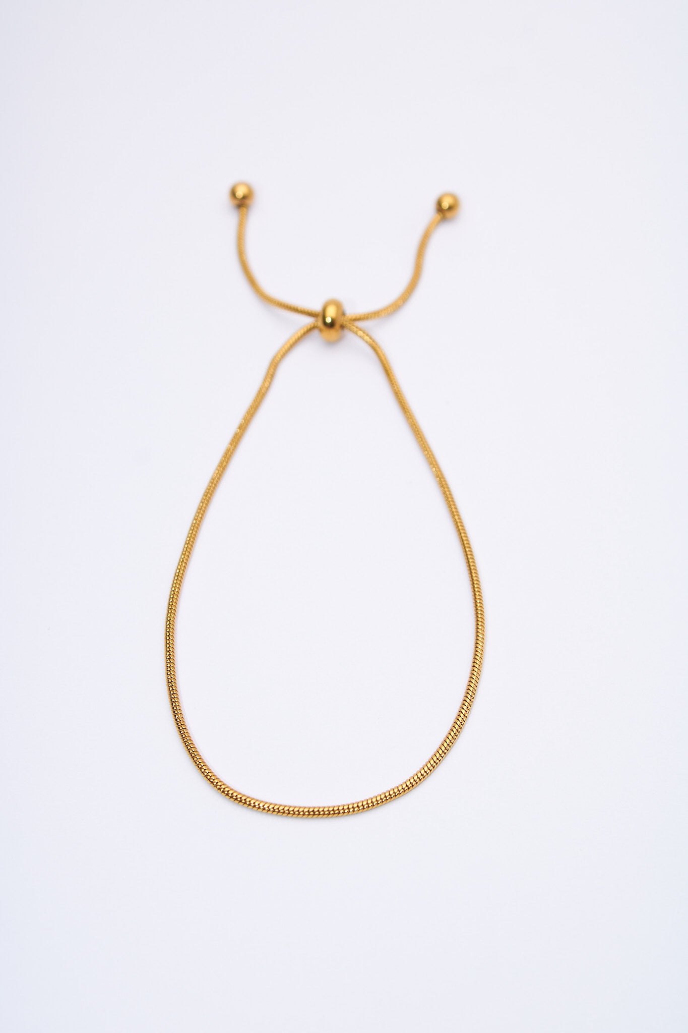 Pulsera ajustable serpiente dorada — deslizador y terminales esféricos