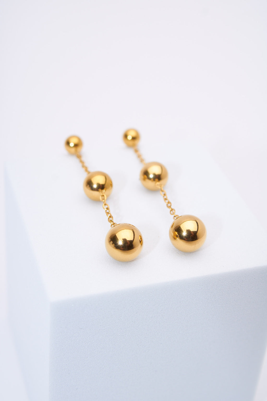 Aretes colgantes bolitas doradas — baño dorado