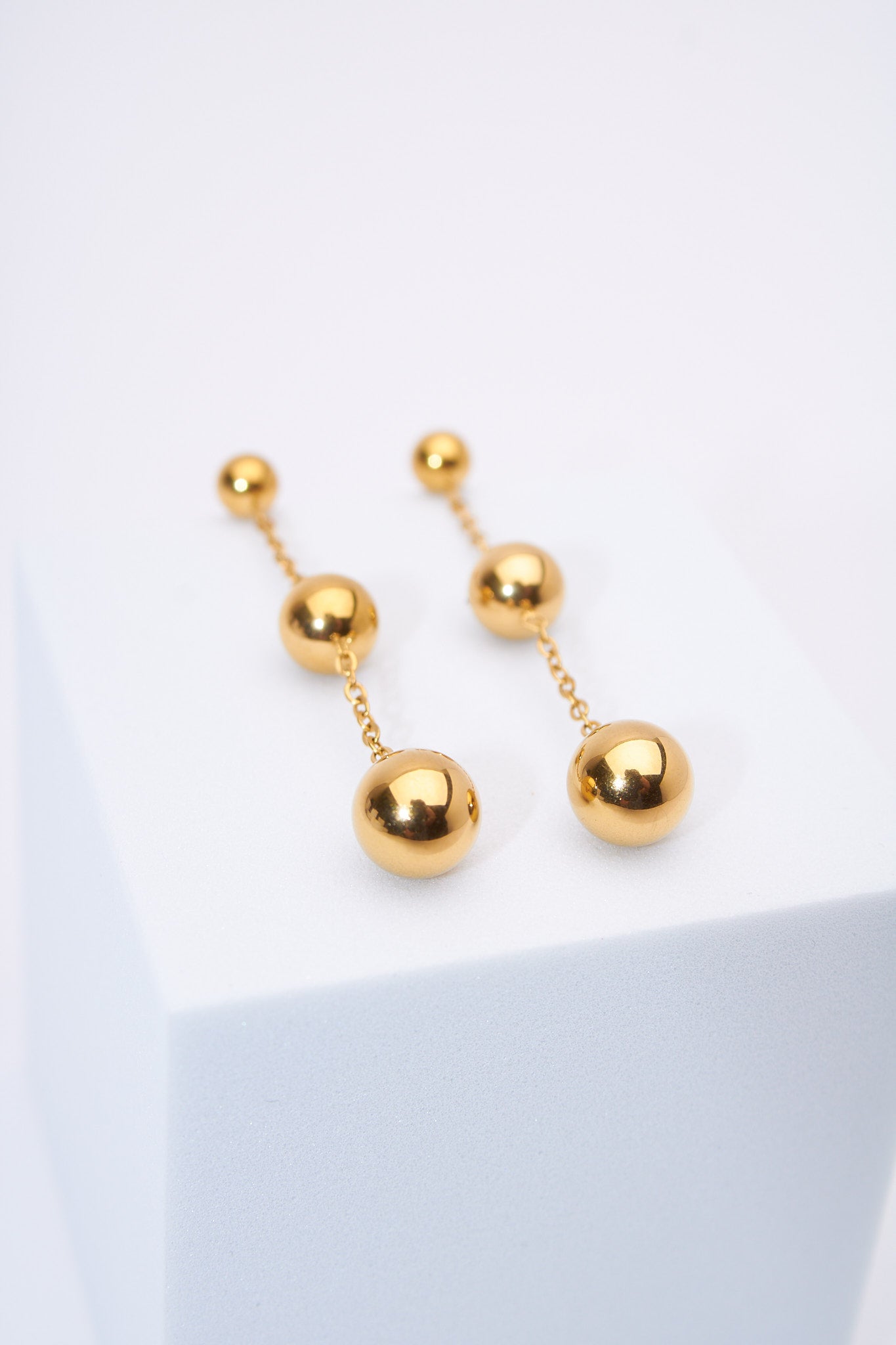 Aretes colgantes bolitas doradas — baño dorado