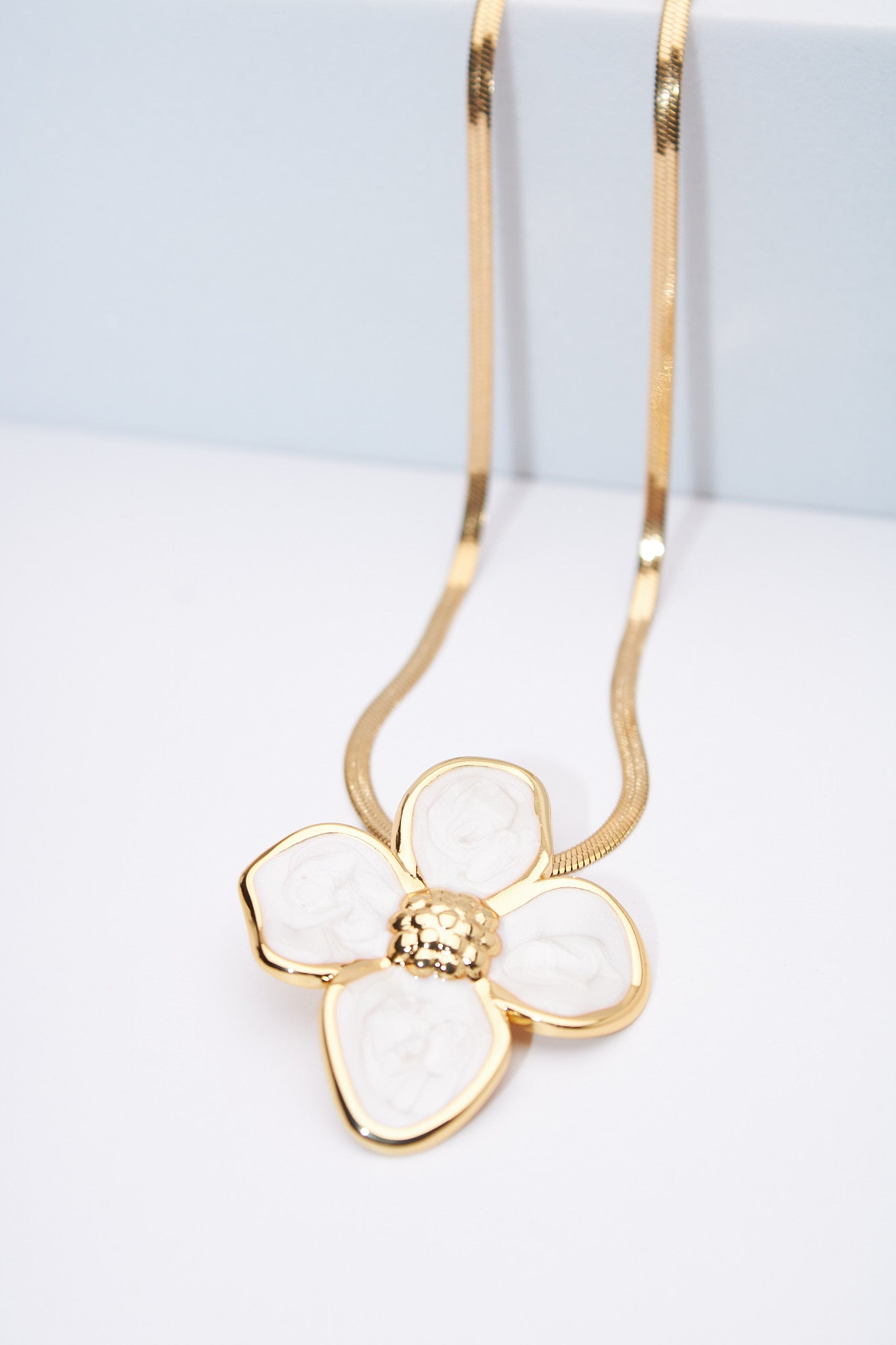 Collar flor esmaltada blanca — baño dorado